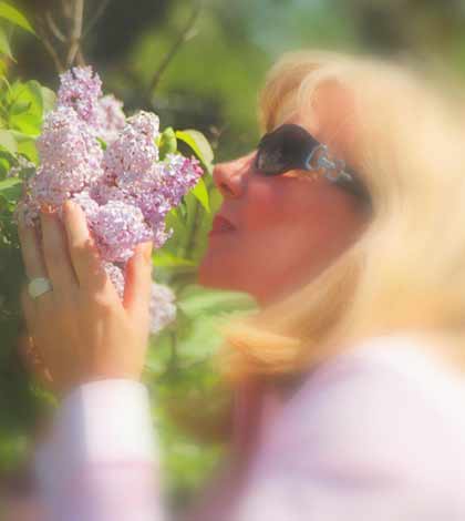 a woman loving flowers and feeling good to achieve wellness in life