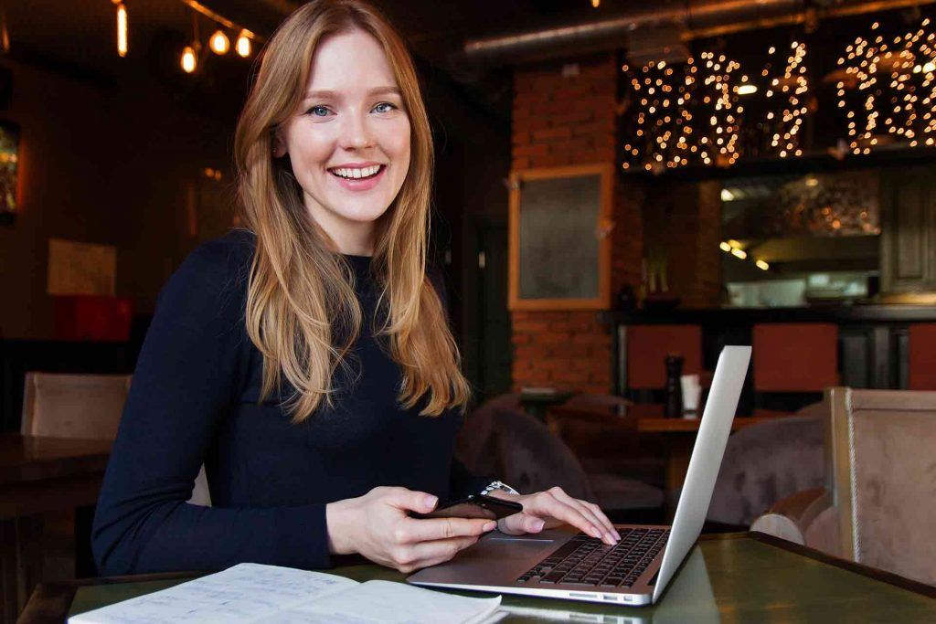 A smiling woman blogger with laptop