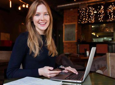A smiling woman blogger with laptop