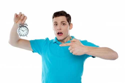 Man showing finger towards clock for time management