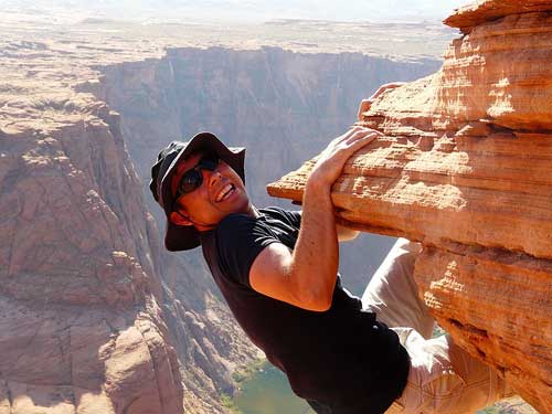 man climbing cliff height with bare hands