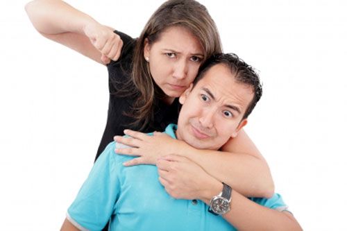 A woman showing a fist to a man expressing abusive relationship.