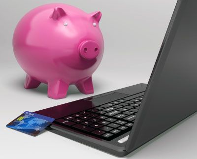 Piggy bank and laptop shown with credit card depicting blogging problems