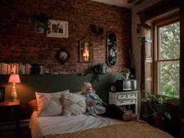 Senior woman sitting on bed in her home
