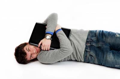 A man lying with laptop in arms
