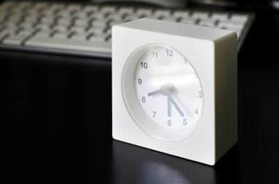 A clock placed in front of a blogger's computer.
