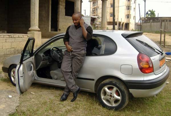 Enstine Muki standing with his car