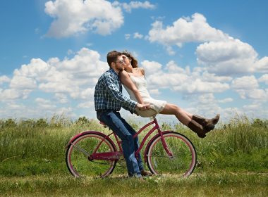 Man riding cycle with woman sitting on the front