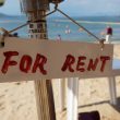 A for rent sign on an umbrella at a beach
