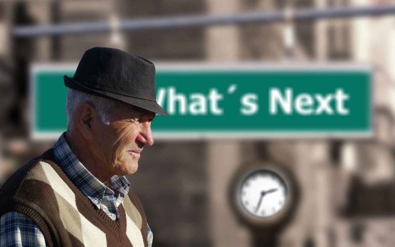 Retired man wearing a hat walking on a street