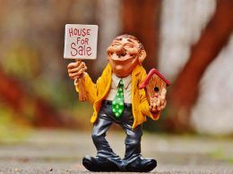 An animated man with house model and placard in hand trying to sell his house