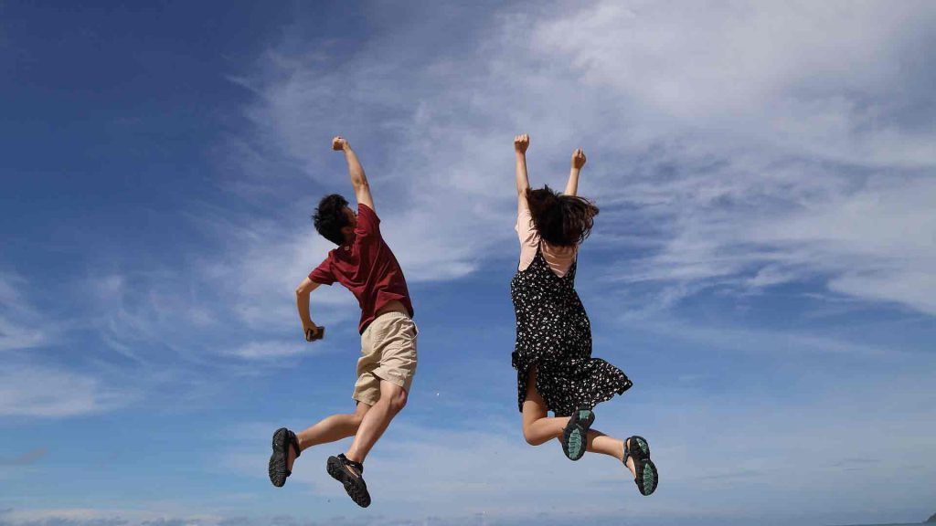 Boy and girl jumping in air enjoying small happy moments