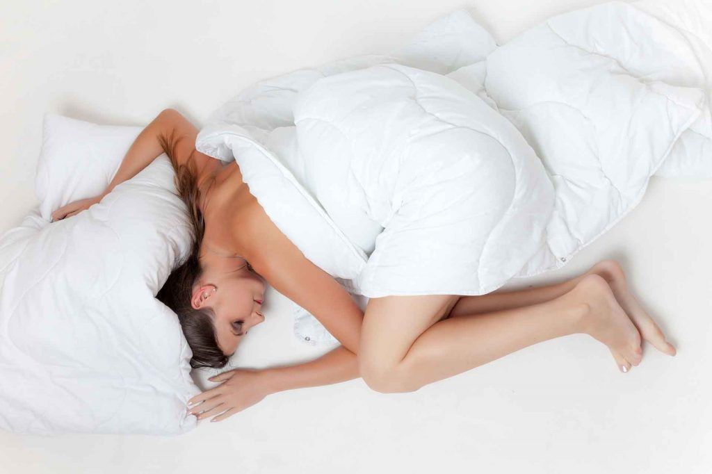 Woman in a spoon sleeping position on bed