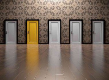 Many white doors with one yellow door signifying career choice among many options
