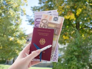 Passport and money in hand as important travel documents