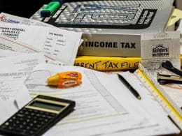Income tax books, calculator, and taxpapers.
