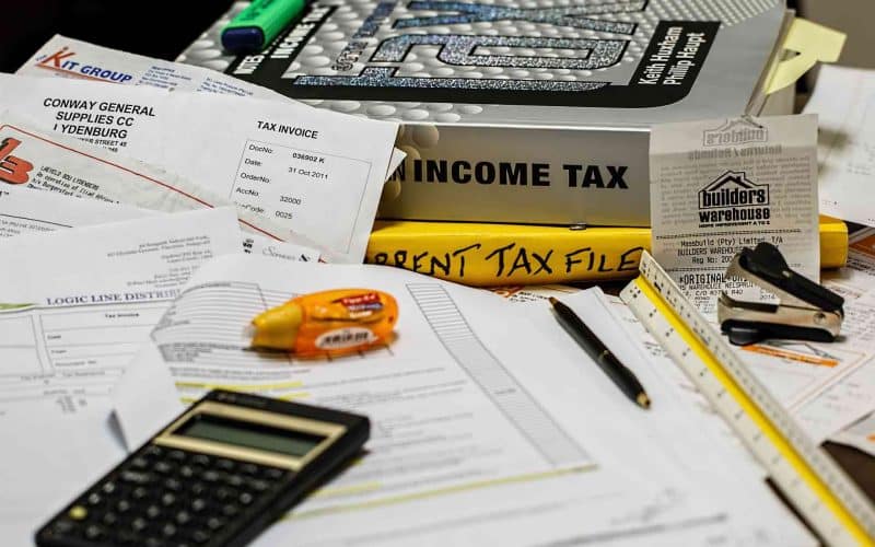 Income tax books, calculator, and taxpapers.