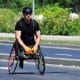 A physically disabled man riding a sports wheelchair.
