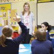 Teacher interacting with students in a classroom at school