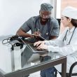 Two healthcare workers sitting and discussing in a hospital.