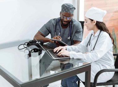 Two healthcare workers sitting and discussing in a hospital.